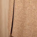 Close-up of a textured beige fabric with a vertical seam.
