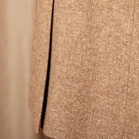 Close-up of a textured beige fabric with a vertical seam.